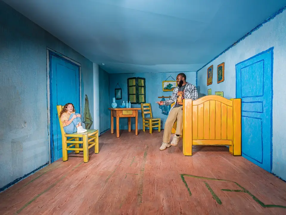 Des visiteurs semblent de tailles différentes dans la salle de perspective bleue de Madurodam.