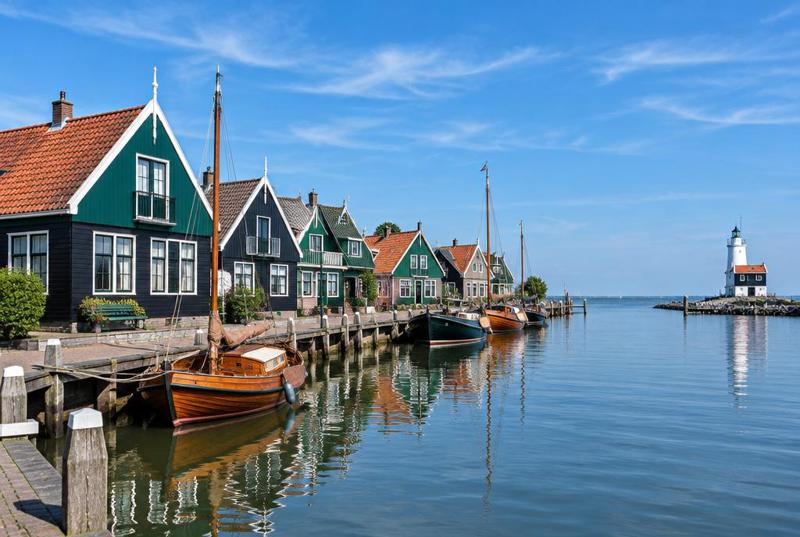The harbour at Marken, traditional green-and-black timber houses and wooden boats beside calm water.