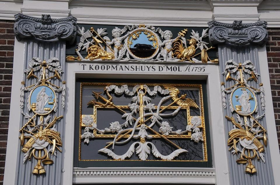 Vergoldete und bemalte Zierarbeiten über der Tür eines Kaufmannshauses von 1795.