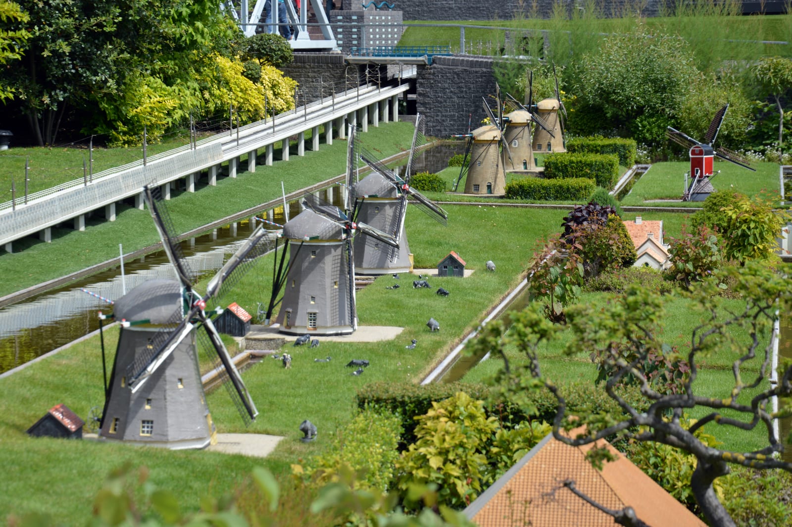 Molens op schaal langs een miniatuurkanaal, in de stijl van de molenrij van Kinderdijk.