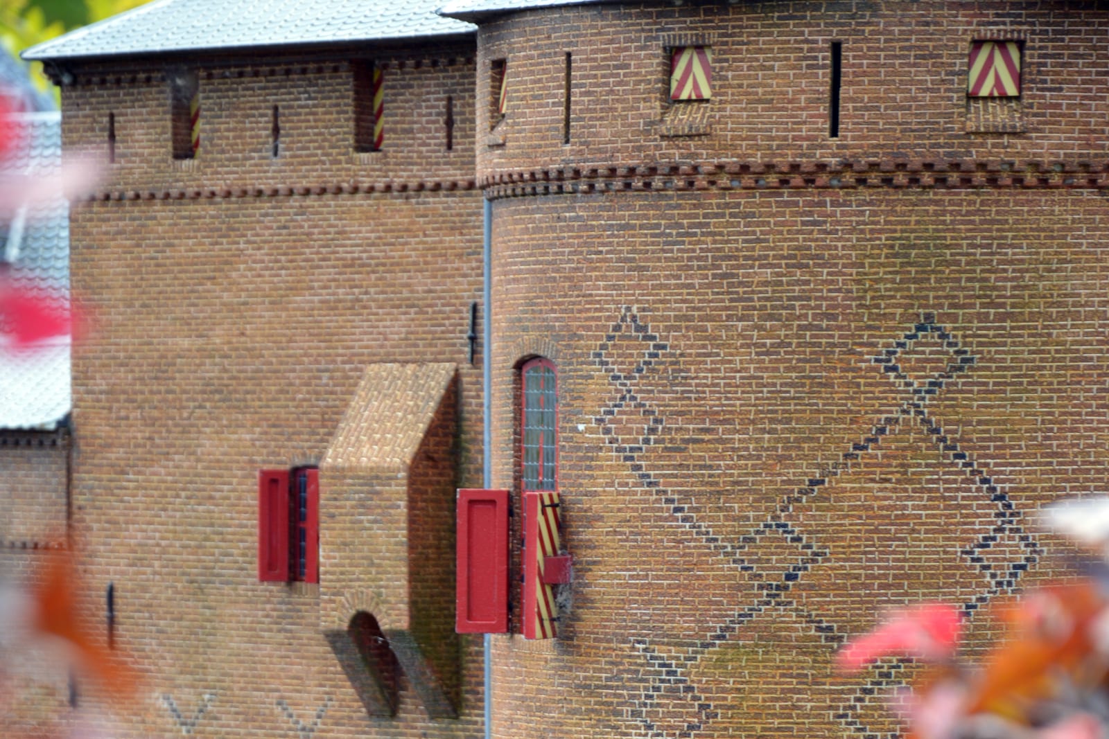 Detail van het model van het Muiderslot, met afzonderlijke bakstenen, rode luiken en een ruitpatroon in het metselwerk.