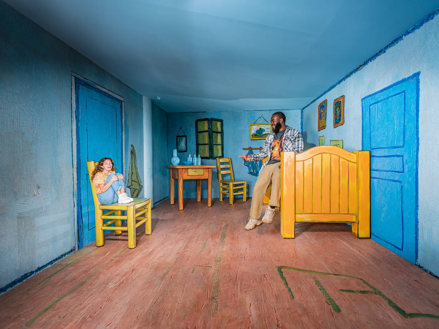 Visitors appearing at different sizes inside the blue perspective room at Madurodam.